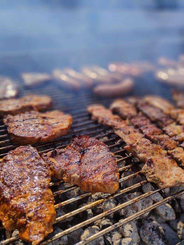 Leckere Fleischspieße, Nackensteaks, Wildbratwurst und Kräuterbratwurst auf dem Grill